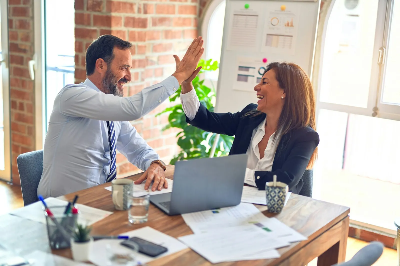 Two colleagues celebrating a successful project with a high five