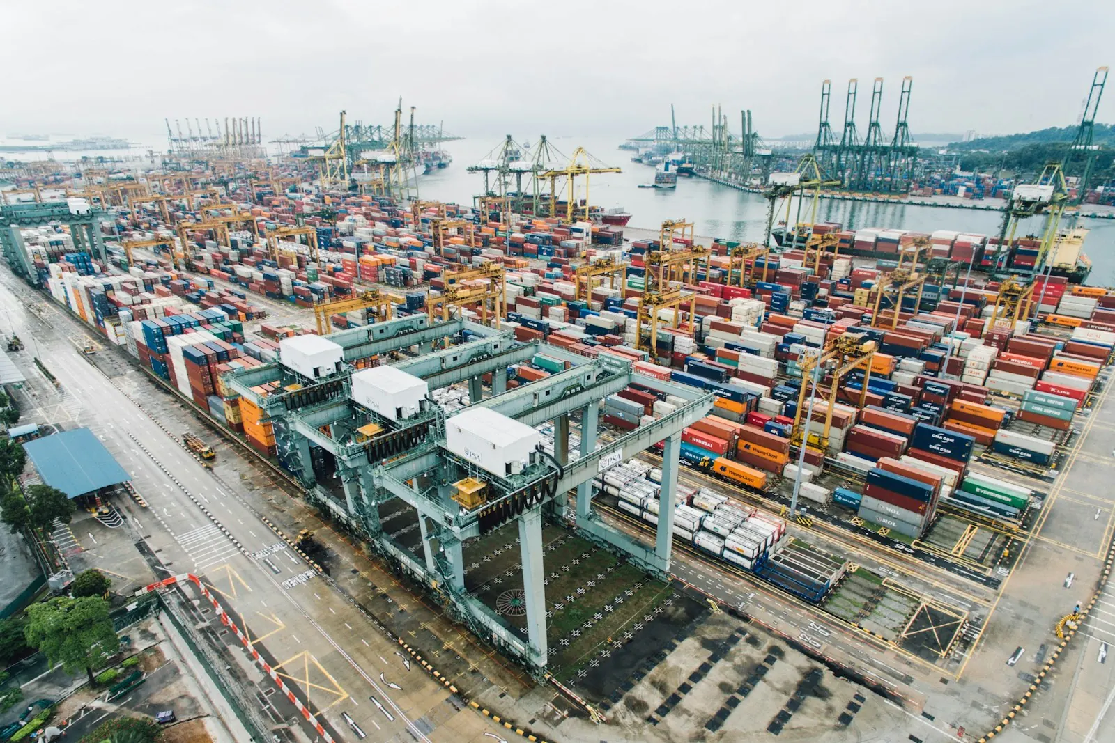 Aerial view of a busy container port with cranes and stacked shipping containers